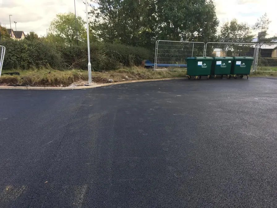 Car park surfacing beside a field